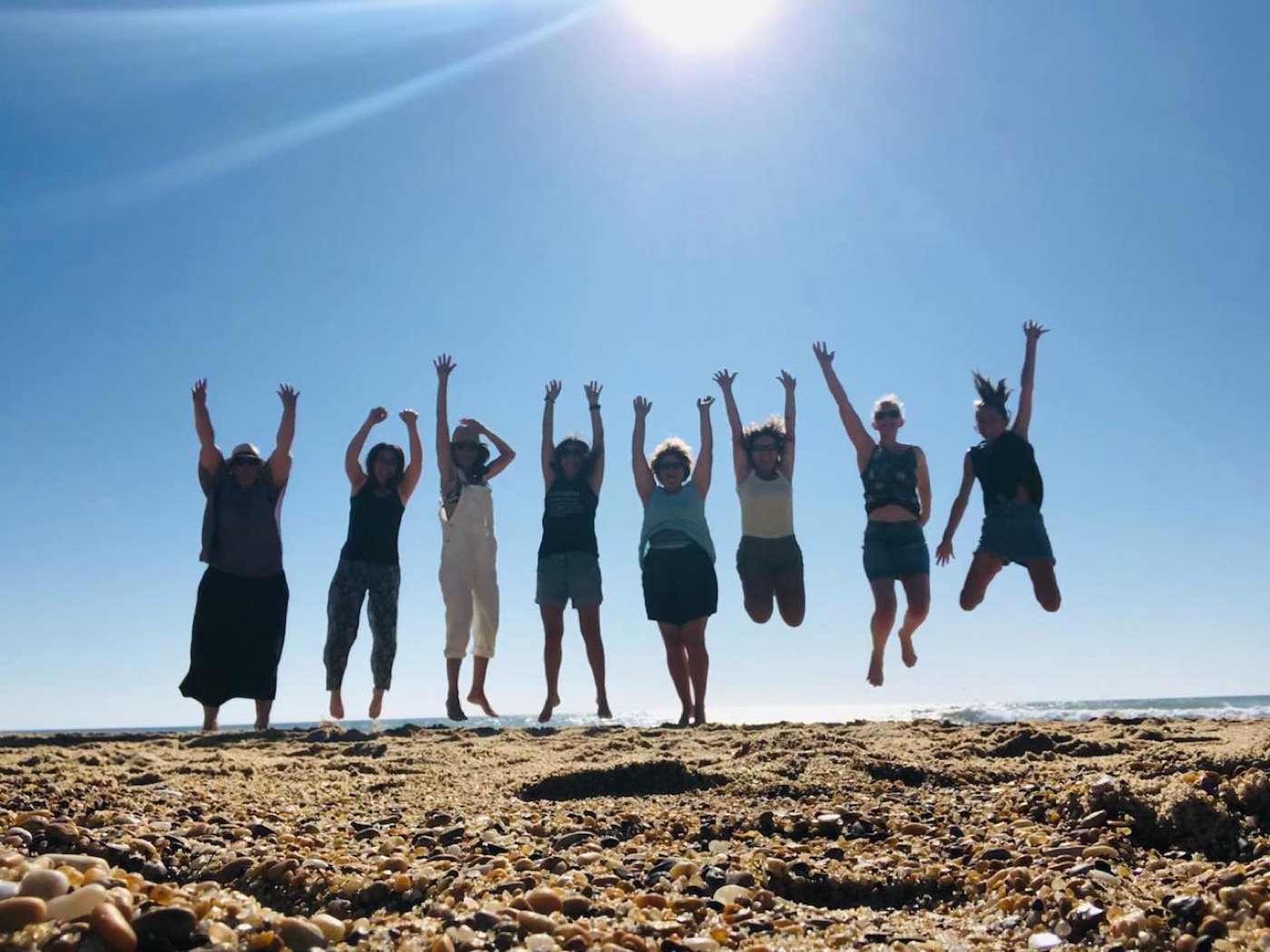 Groupe de stagiaires sautant de joie sur la plage